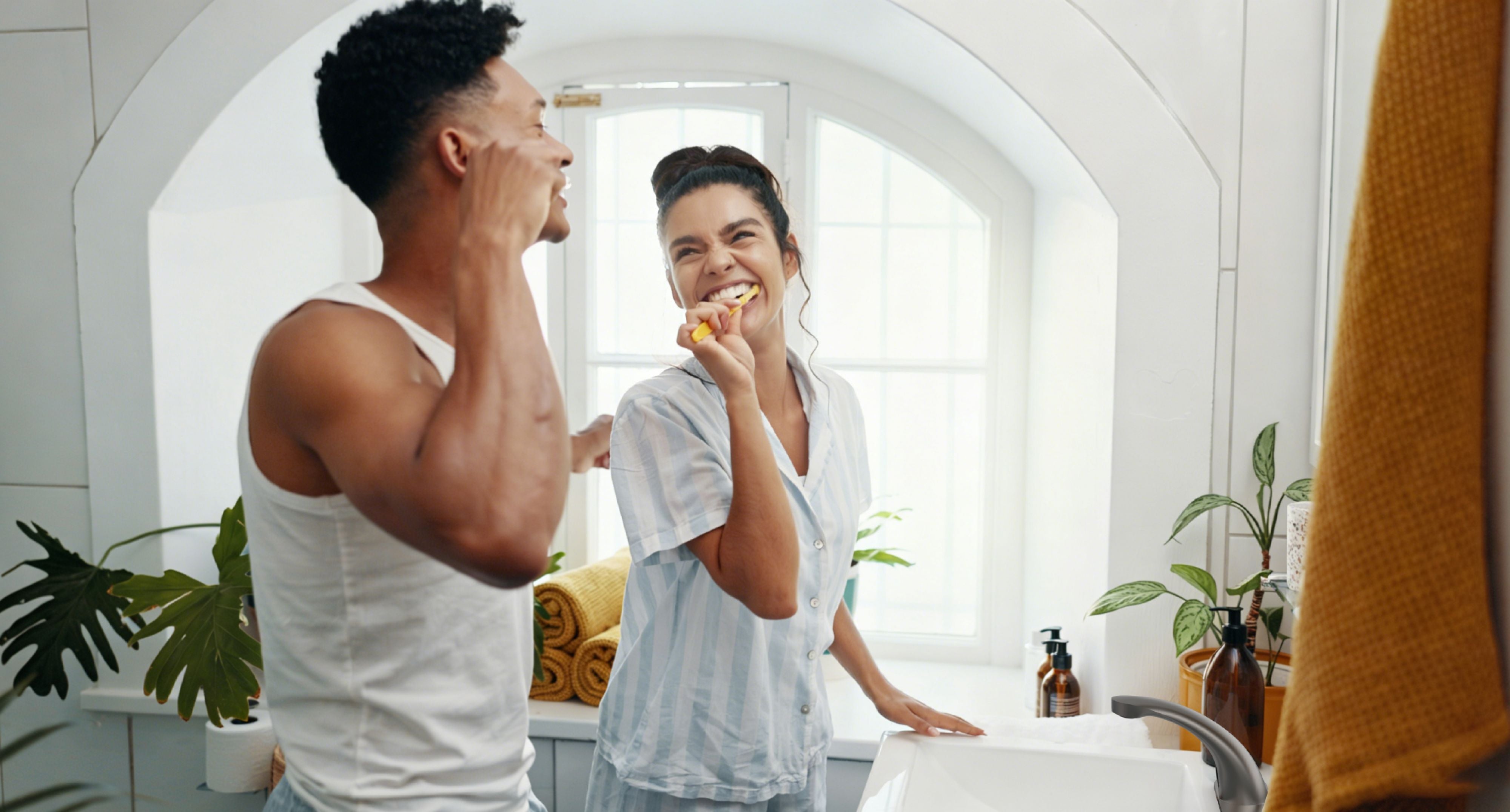 Two people in a bathroom, brushing their teeth with a Primsoph brand sensor faucet.