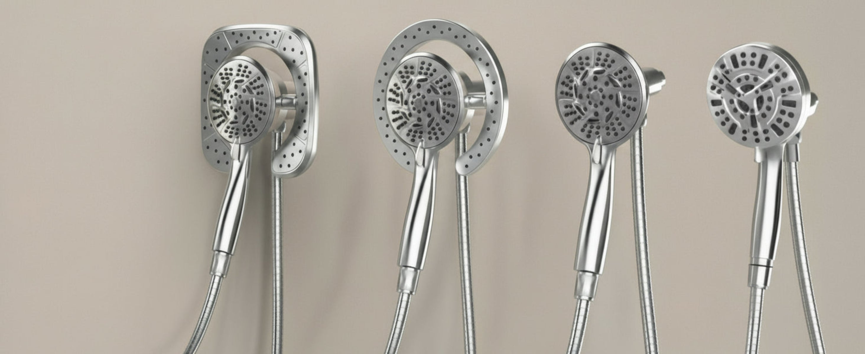 Set of five silver handheld shower heads on a beige background